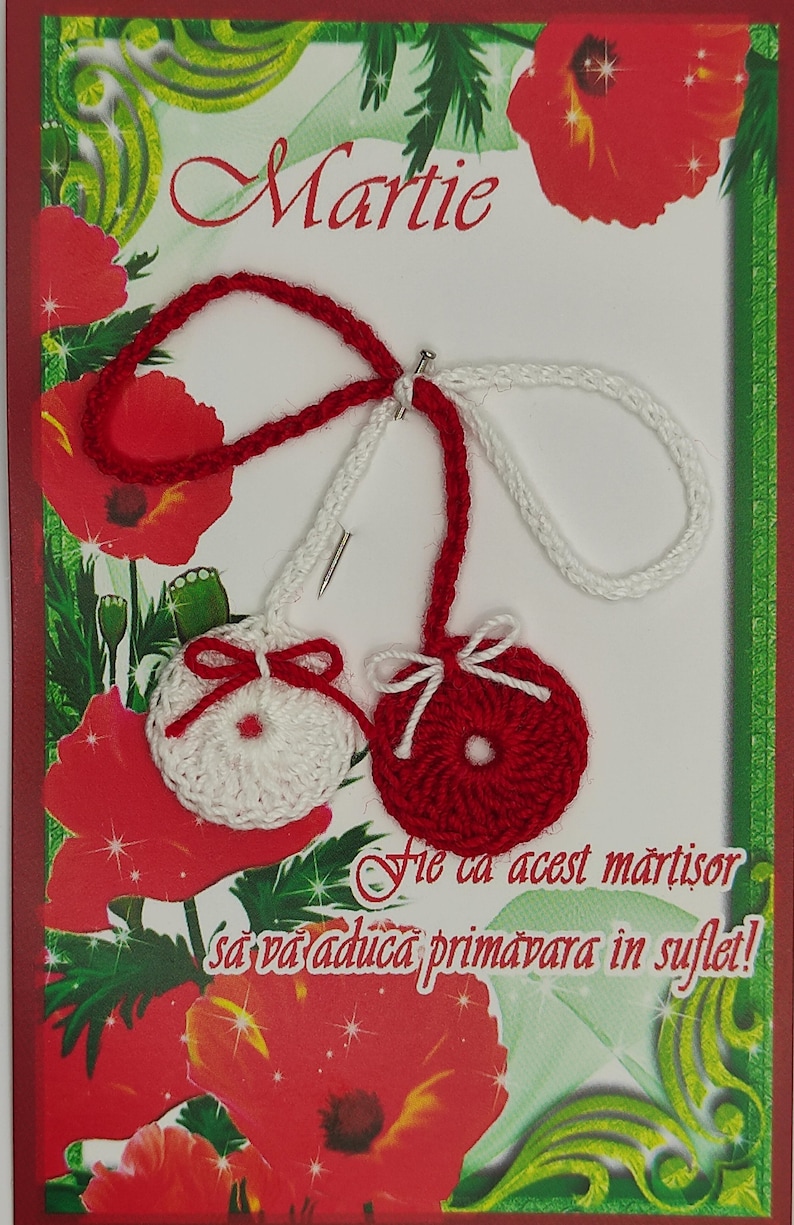 May include: A red and white crocheted martisor with a red bow and a white bow. The martisor is on a card with the name "Martie" and the text "Fie ca acest martisor sa va aduca primavara in suflet!"