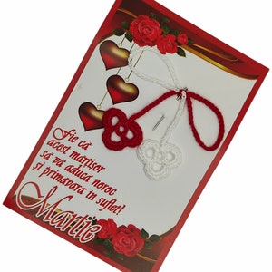 May include: Red and white crocheted heart charms with a red and white string attached to a red card with the text "Fie ca acest martisor sa va aduca noroc si primavara in suflet! Martie".