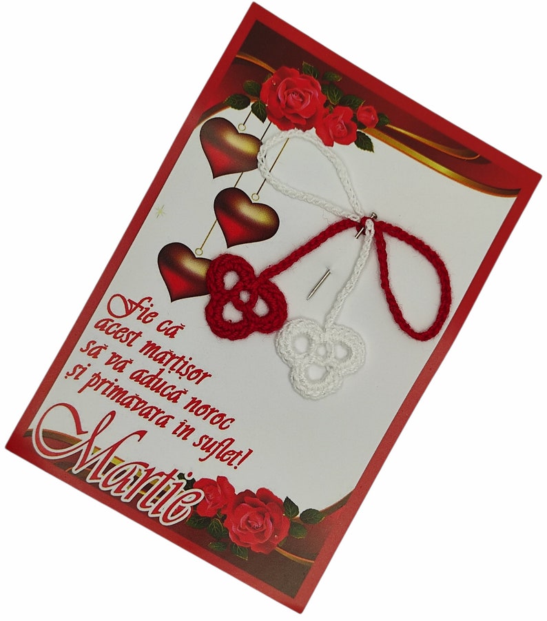 May include: Red and white crocheted heart charms with a red and white string attached to a red card with the text "Fie ca acest martisor sa va aduca noroc si primavara in suflet! Martie".