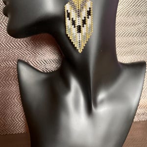 May include: A white ceramic mug with a black handle and the text "But First, Coffee" in a black, bold font. The mug is on a white surface.