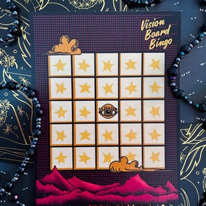 Puede incluir: Una tarjeta de Bingo de Vision Board con una cuadrícula de cuadrados, cada uno con una estrella amarilla. La tarjeta tiene un fondo púrpura con las palabras "Vision Board Bingo" en una fuente de escritura. La parte inferior de la tarjeta presenta una cordillera roja y dos nubes naranjas.