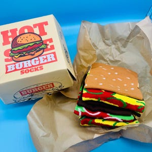 Könnte beinhalten: Ein Set aus drei Keramikbechern mit gesprenkelter, matter Oberfläche. Die Becher sind in den Farbtönen Creme, Hellgrau und Dunkelgrau gehalten. Jeder Becher hat ein schlichtes, minimalistisches Design, perfekt für Kaffee oder Tee.