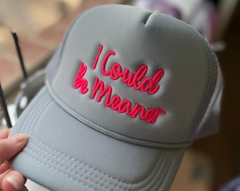 May include: Gray trucker hat with a pink embroidered message that reads "I Could Be Meaner".