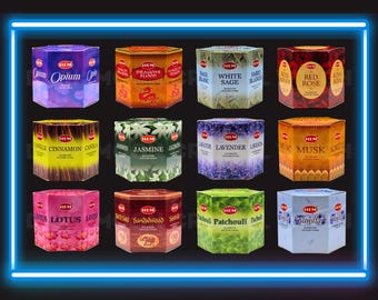 Peut inclure: Une collection de douze boîtes hexagonales d'encens HEM. Chaque boîte présente un parfum différent, notamment Opium, Dragons Blood, Sauge Blanche, Rose Rouge, Cannelle, Jasmin, Lavande, Musc, Lotus, Bois de Santal, Patchouli et Vanille. Les boîtes sont encadrées par une lumière néon bleue.