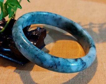 May include: A jade bangle bracelet with a light green and dark green marbled pattern.