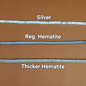 Pu&ograve; includere: Tre file di catena in argento e ematite, etichettate "Argento", "Ematite Reg." e "Ematite pi&ugrave; spessa".