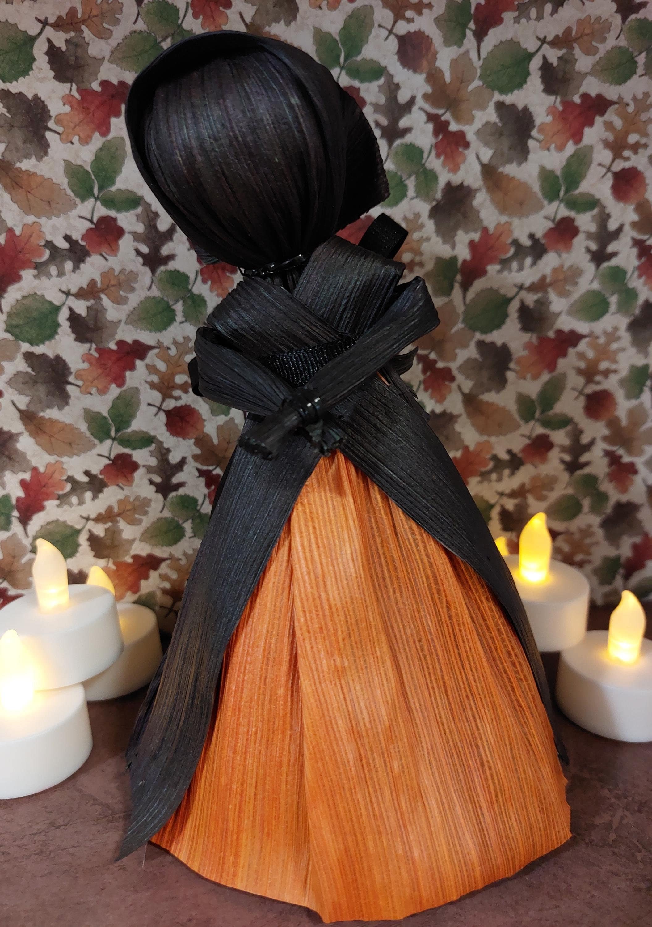Orange and black corn husk doll