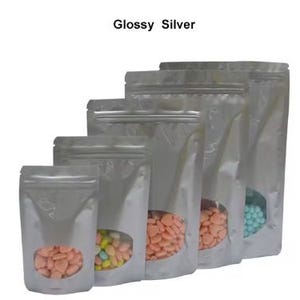 May include: Five silver stand-up pouches with clear viewing windows. The pouches are different sizes and contain colorful candies. The text "Glossy Silver" is at the top of the image.