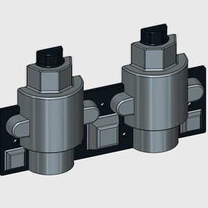 Op de afbeelding: Een mechanische assemblage met dubbele cilinder gemonteerd op een rechthoekige zwarte basisplaat. De twee metaalgrijze cilindrische eenheden hebben zeshoekige bovenkanten met zwarte halfronde doppen en kleine zijwaarts uitstekende lipjes.