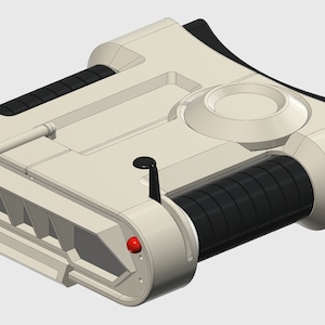 Puede incluir: Un juguete blanco y negro con un botón rojo y una palanca. El juguete tiene una forma cilíndrica con una parte superior redondeada y una parte inferior plana. Tiene una serie de anillos negros en un lado y un pequeño botón blanco redondo en el otro.