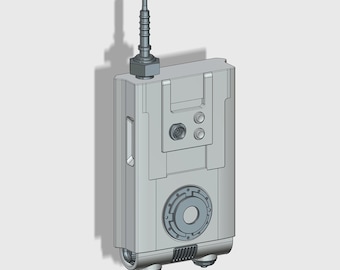 May include: A gray, rectangular device with a black circular area in the center, two small buttons, and a long antenna on top. The device has two small wheels on the bottom.