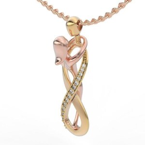 May include: A rose gold and gold pendant necklace featuring an intertwined couple design. The pendant has an infinity symbol shape, with one side encrusted with small, clear gemstones. The necklace chain is also rose gold.