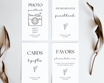 Puede incluir: Cuatro carteles blancos con texto negro e ilustraciones. Los carteles son para una boda e incluyen el texto "PHOTO guestbook", "PLEASE SIGN OUR guestbook", "CARDS & gifts" y "FAVORS please take one THANK YOU FOR SHARING IN OUR SPECIAL DAY". Cada cartel incluye una pequeña ilustración de corazón y el texto "taylor & matt 10.07 2006".
