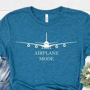 May include: A teal blue t-shirt with a white airplane graphic and the text "AIRPLANE MODE".