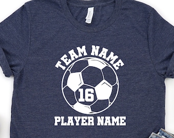May include: A navy blue t-shirt featuring a white soccer ball graphic and the text "TEAM NAME PLAYER NAME". The soccer ball has the number 16 in the centre.