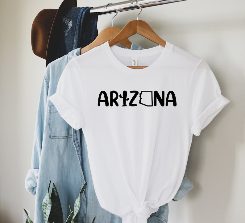 May include: White t-shirt with black text that reads "ARIZONA" and a black outline of the state of Arizona.