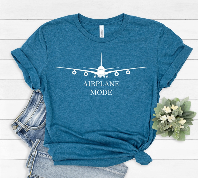 May include: A teal blue t-shirt with a white airplane graphic and the text "AIRPLANE MODE".