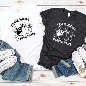 May include: Two t-shirts with a bowling ball and pins graphic. The text on the shirts reads "Team Name Player Name".