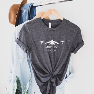 May include: A dark gray t-shirt with a white airplane graphic and the text "AIRPLANE MODE" printed on the front.