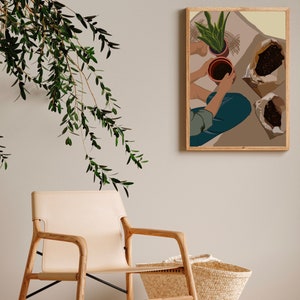May include: A framed illustration of a person potting plants. The illustration is in a modern style with muted colors and features a person in blue jeans and a brown shirt. The person is holding a terracotta pot with a green plant in it. There are two bags of soil on the floor.