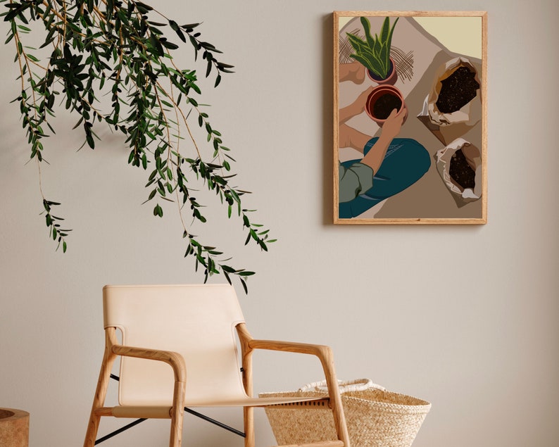 May include: A framed illustration of a person potting plants. The illustration is in a modern style with muted colors and features a person in blue jeans and a brown shirt. The person is holding a terracotta pot with a green plant in it. There are two bags of soil on the floor.