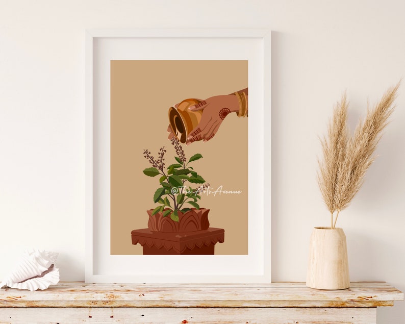May include: A hand pours water from a golden pitcher onto a potted tulsi plant. The plant is in a terracotta pot with a decorative base. The background is a light brown color.