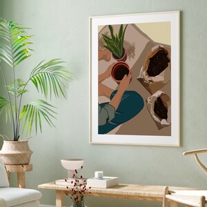 May include: A framed illustration of a person potting plants. The illustration is in a minimalist style with brown, green, and beige colors. The person is wearing blue jeans and a green shirt. There are three brown pots with plants and two bags of soil on the floor.