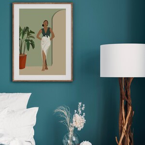 May include: A framed illustration of a woman standing in a doorway with a green plant in a terracotta pot. The woman is wearing a green top and a white skirt. The background is a light green color.