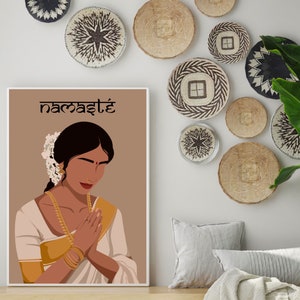 May include: A digital illustration of a woman with dark hair and brown skin wearing a white and gold sari. She is holding her hands together in a prayer position. The background is a light brown color and the text "namaste" is written in black at the top of the image.