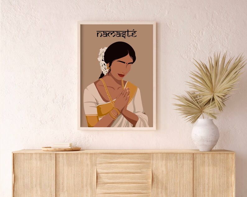 May include: A digital illustration of a woman in a white and gold sari with her hands in a prayer position. The background is a light brown color and the text "namaste" is written in black at the top of the image.