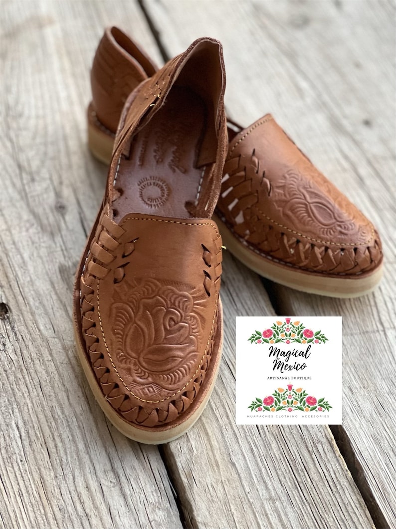 Peut inclure: Sandales huaraches en cuir marron avec un motif floral en relief. Les sandales &agrave; bout ouvert pr&eacute;sentent des d&eacute;tails tress&eacute;s et une semelle de couleur cr&egrave;me. L'image comprend le logo de Magical Mexico.