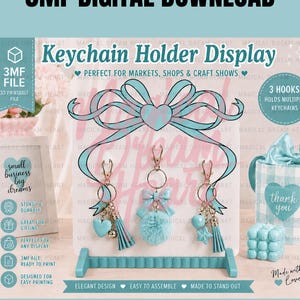 May include: A light blue 3D printable keychain holder display featuring a large bow at the top and three hooks. The display is labelled 3MF DIGITAL DOWNLOAD and Keychain Holder Display, with text indicating 3 hooks and 3MF file ready to print.