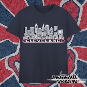 May include: Navy blue t-shirt featuring a white skyline design with the text "CLEVELAND" in white and red. The shirt includes player names in white, and the website "LEGEND SKYLINE.COM" is visible at the bottom.