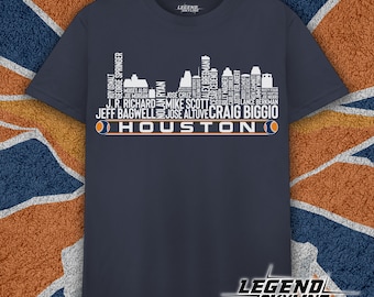May include: A navy blue t-shirt with a white graphic of the Houston Astros skyline. The graphic includes the names of notable players, including Jeff Bagwell, Jose Altuve, and Craig Biggio. The text "Houston" is printed below the graphic.