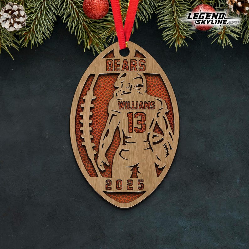 May include: Wooden football-shaped ornament with a football player silhouette. The ornament features the word "BEARS" at the top, the name "WILLIAMS" and the number "13". The year "2025" is at the bottom. A red ribbon is attached for hanging.