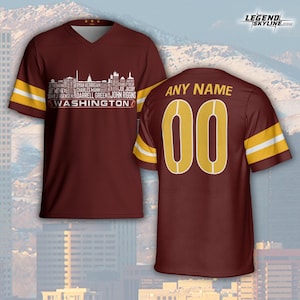 Peut inclure: Maillot bordeaux &agrave; col en V avec des rayures blanches et dor&eacute;es sur les manches. Le devant pr&eacute;sente un graphisme de skyline blanc avec des noms de joueurs et le texte "WASHINGTON". Le dos affiche "ANY NAME" au-dessus du num&eacute;ro "00" en or.