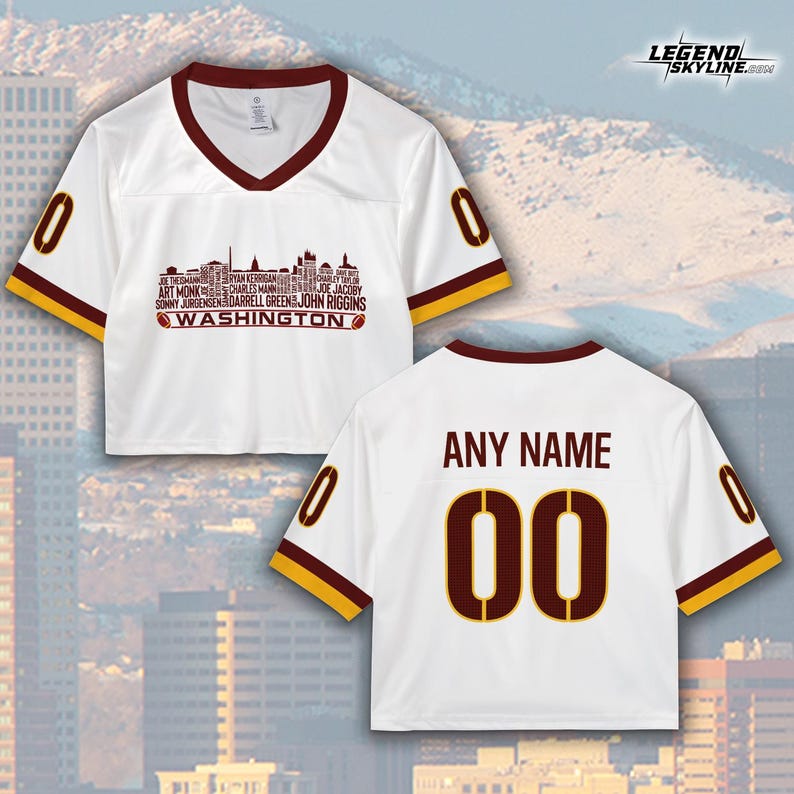 Peut inclure: Maillot court blanc avec des bordures bordeaux et dor&eacute;es. Il pr&eacute;sente le mot "WASHINGTON" et les noms des joueurs dans un design de skyline. Le dos affiche "ANY NAME" et le num&eacute;ro "00".