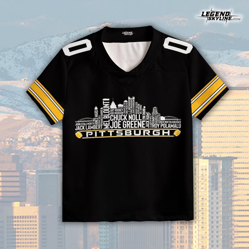 May include: Black football jersey with white and gold accents. The jersey features a V-neck and the word "Pittsburgh" with player names and a skyline graphic. The jersey has the Legend Skyline logo.