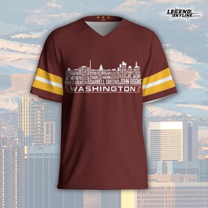 Peut inclure: Maillot bordeaux &agrave; col en V avec des rayures dor&eacute;es et blanches sur les manches. Le maillot pr&eacute;sente un graphisme de skyline blanc avec des noms de joueurs et le mot "WASHINGTON" en dessous. Le maillot porte le logo Legend Skyline.