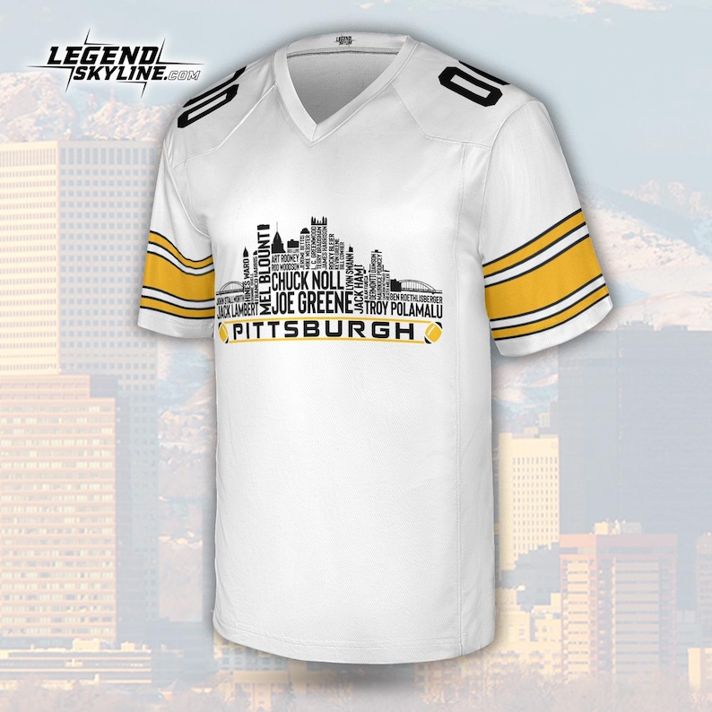 May include: White football jersey with black and gold accents. The jersey features the word "PITTSBURGH" and a skyline design with player names. The sleeves have gold stripes, and the number "10" is on the shoulders.
