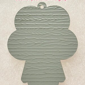 May include: A gray metal charm in the shape of a clover with a textured surface. The back of the charm is gray.