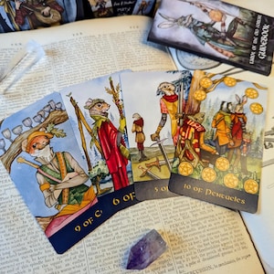 May include: A set of tarot cards featuring illustrations of woodland creatures. The cards show a badger, a squirrel, a rabbit, and a fox. The cards are numbered 9 of Cups, 6 of Swords, 5 of Swords, and 10 of Pentacles. The cards are on a book with a text about Perch.