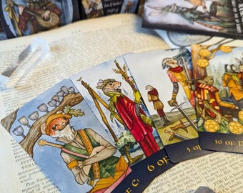 May include: A Tarot of the Old Forest deck featuring illustrated cards with anthropomorphic animals. The cards display the 9 of Cups, 6 of Wands, 5 of Swords, and 10 of Pentacles, resting on an open book with a clear quartz and amethyst crystal.