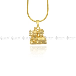May include: A gold pendant necklace featuring a depiction of the Hindu deities Shiva and Parvati. The pendant is intricately detailed and has a traditional design.