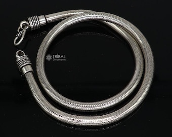 Può includere: Una collana a catena di serpente d'argento con finitura testurizzata. La catena è arrotolata e pronta per essere indossata.