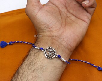Aarohi Jewells OM Rakhi With Crystal & Rudraksha - Gold Plated Cotton Rakhi For Brother (Rakshabandhan)