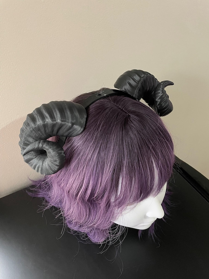 3D printed black ram horns mounted to a black headband displayed on a mannequin