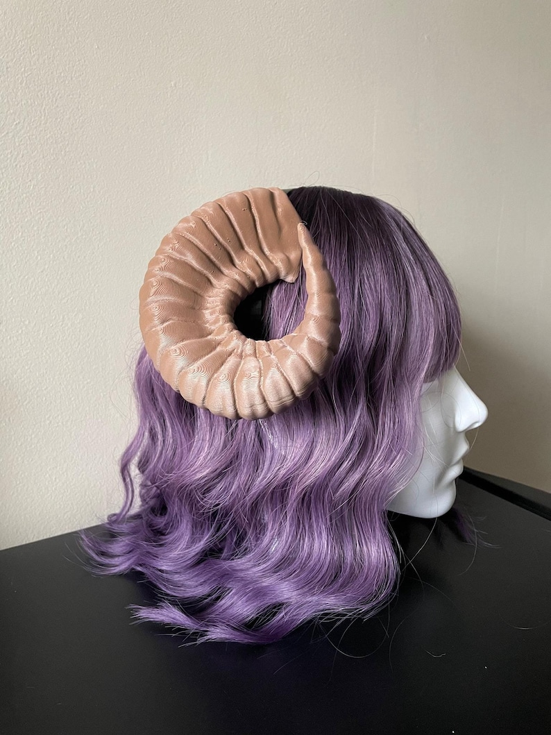 3D printed dark brown Nordic Ram Horns mounted to a black headband displayed on a mannequin