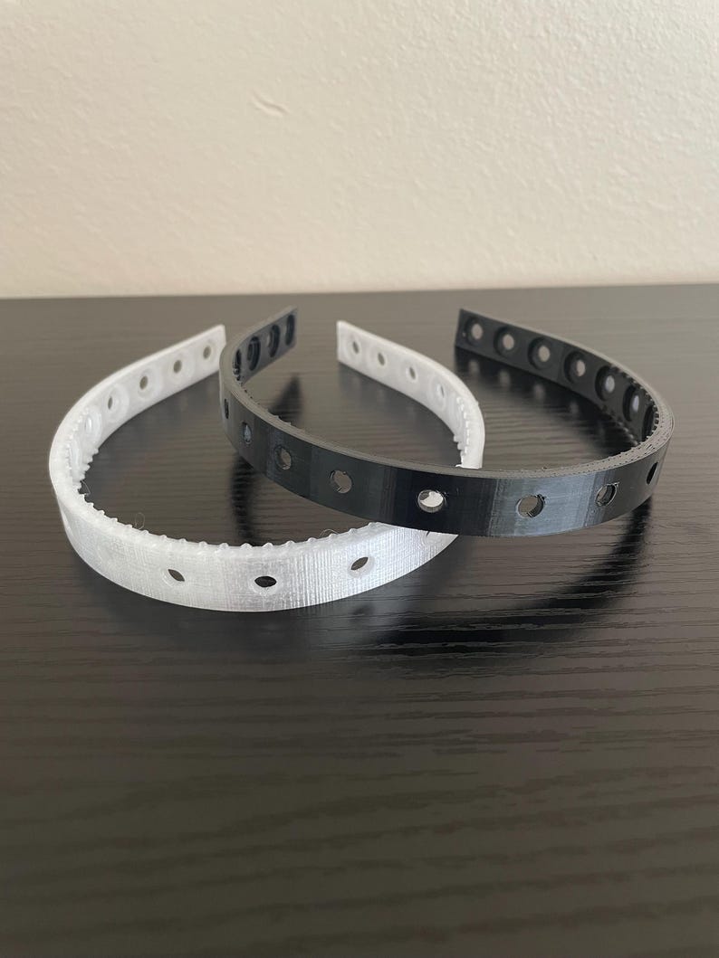 A semi clear and black headband featuring multiple screw holes for mounting horns and ears