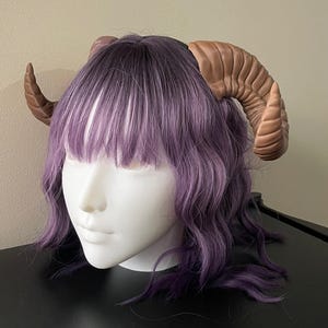 3D printed dark brown Nordic Ram Horns mounted to a black headband displayed on a mannequin